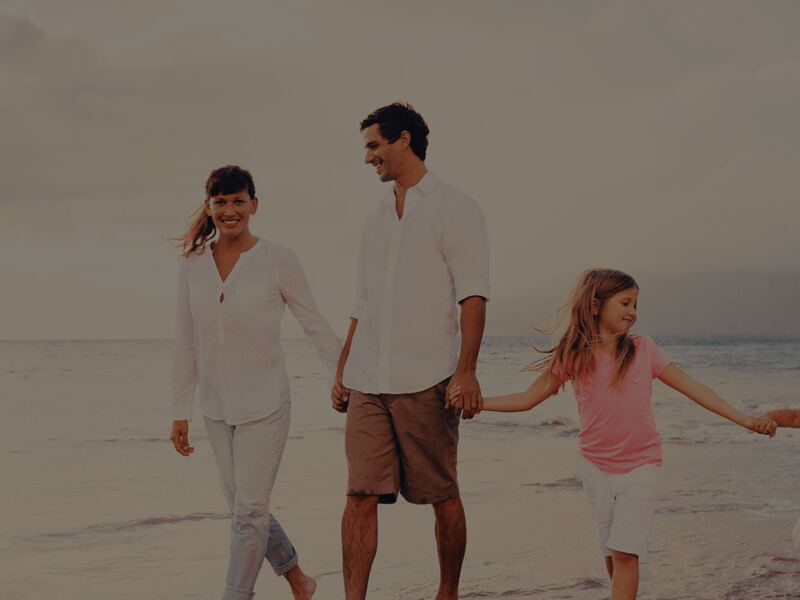 Parents walking on the beach with their two children